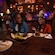 A girl in a Minnie Mouse ear headband laughing with a woman at Beak & Barrel restaurant in Magic Kingdom park