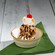An ice cream sundae topped with whipped cream, chocolate sauce, a cherry and nuts