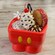 An ice cream sundae complete with whipped cream and a cookie sandwich served in a bowl shaped like Mickey Mouse’s pants