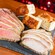 Slices of carved beef and turkey next to pieces of focaccia bread