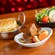 A bowl of pot roast next to chicken pot pie and a salad with vegetables, at Chef Mickey’s