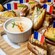Un plateau avec des sandwiches Croque Monsieur miniatures ornés de drapeaux français et un petit bol de sauce béchamel