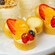 Three Mickey Mouse shaped pastry tarts filled with cream and topped with strawberries, orange slices and blueberries