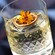 A cocktail topped with and orange slice and flower