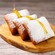 Beignets cubiertos de azúcar glas y rociados con miel sobre una tabla de madera