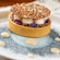 A tart topped with brown butter panna cotta spheres, surrounded by cocoa nib tuille, edible flower petals and maple creme anglaise