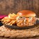 A Smoked Pork Sandwich topped with coleslaw and sauce served with French fries on a plate