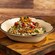 A Barbacoa Beef Bowl from Sunshine Seasons with braised meat, cilantro-lime rice, black beans, onions, peppers, cotija, and pico de gallo