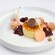 A crème brûlée surrounded by sugared beignets and cherry compote