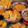 A breakfast buffet spread with Mickey shaped waffles, sausages, ham, pastries and roasted potatoes