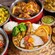 A buffet spread of spiced meats, rice, vegetables, flatbreads and desserts 