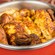 Spiced rotisserie chicken pieces in a serving pot