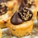 Mini cookie cups topped with chocolate ganache and chopped nuts