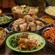Several platters of lunch and dinner foods, including chicken, beef, green beans and assorted salads