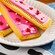 Pastries topped in frosting, bacon and candy resting on a plate and a tablecloth