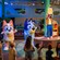 Bluey and Bingo characters on stage with a performer holding an asparagus sign