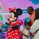 Minnie Mouse signing the autograph books of 2 children as their parents watch