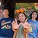A young girl in a Minnie Mouse ear headband making the letter W with her hands while her parents look on