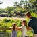 A guide and a family watching 2 elephants near a tram carrying guests at Harambe Wildlife Preserve  