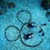 Scuba divers floating above the sandy floor of a aquarium tank, with the Mickey Mouse logo made from stones  