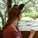 A woman watching a giraffe from a tram at Harambe Wildlife Preserve