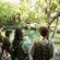 4 people in safari vests stand near water watching wildlife at Disney’s Animal Kingdom theme park