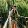 A girl wearing Mickey ears and a vest stands on a rope bridge at Disney's Animal Kingdom theme park