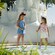 Two children holding putters while standing in front of large white sandcastle structure at Winter Summerland Miniature Golf