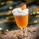 A frozen orange cocktail topped with foam and a dried citrus garnish from Hurly Burly at Disney’s Boardwalk
