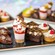 Assorted mini desserts including brownies, tarts and treats arranged on a tray
