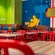 Dining tables and booths with a pop art mural featuring Mickey Mouse at Everything Pop Shopping & Dining in Disney’s Pop Century Resort