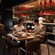 A couple laughing together at a table beside Capa’s open kitchen