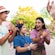 A family of 4 doing bird inspired hand signs along with a Cast Member in Disney's Animal Kingdom theme park