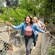 Tres adultos jóvenes caminando por una plancha de madera y un puente de cuerda en Pirate's Lair en Tom Sawyer Island