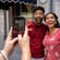 A couple poses for a picture in front of a shop while the mobile device taking the picture shows the logo for the Disneyland Resort and other augmented reality effects
