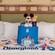 A Disneyland Resort 70th Celebration welcome basket, plush Mickey Mouse, photo frame and blanket on a Disneyland Resort hotel bed