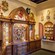 A section of Il Bel Cristallo at Epcot with carved wooden cabinets displaying Venetian carnival masks
