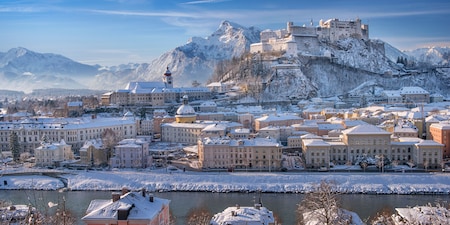 Picturesque Salzburg with snow covering the streets, buildings and surrounding mountains