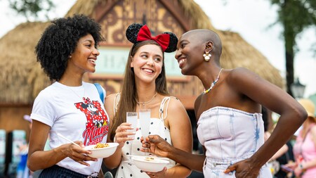 Three Guests enjoying food and drinks at the Hawaii booth during the EPCOT International Food & Wine Festival 