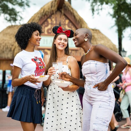 Three Guests enjoying food and drinks at the Hawaii booth during the EPCOT International Food & Wine Festival 