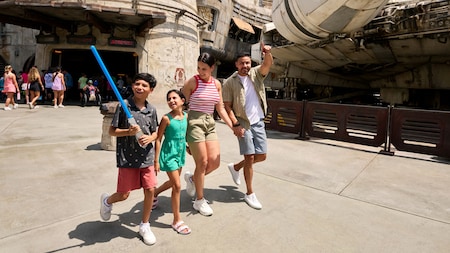 Una familia caminando junto al Millennium Falcon en Star Wars: Galaxy’s Edge