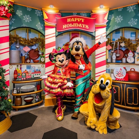 Minnie Mouse, Goofy and Pluto waiting to greet Guests near a holiday themed photo op