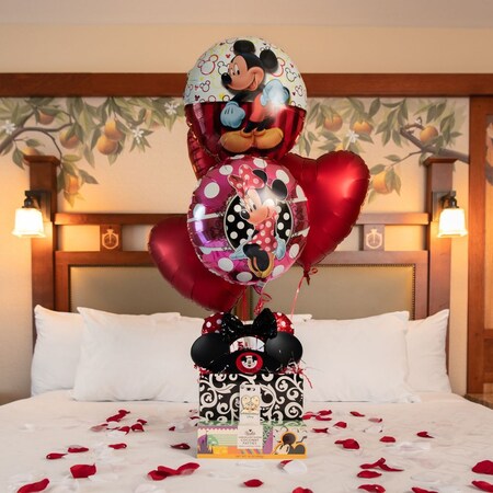 Una canasta de bienvenida de celebración romántica sobre una cama de hotel del Disneyland Resort
