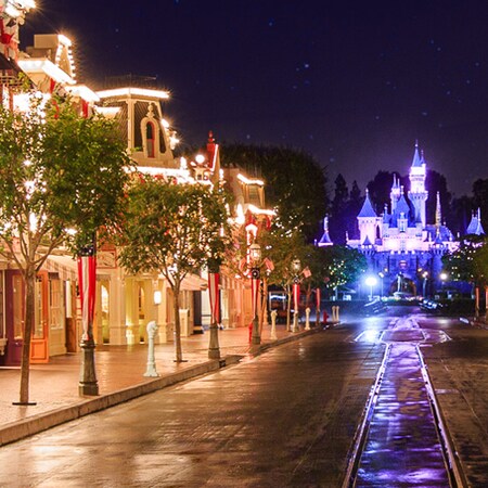 Festive lights illuminating Disneyland Park as Main Street, U.S.A. leads to Sleeping Beauty Castle
