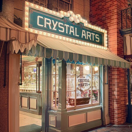 Fine crystal glassware sparkles in the evening while lining the window displays at Crystal Arts