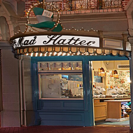 Patriotic flags cascading from the storefront as lights outside The Mad Hatter illuminate the night