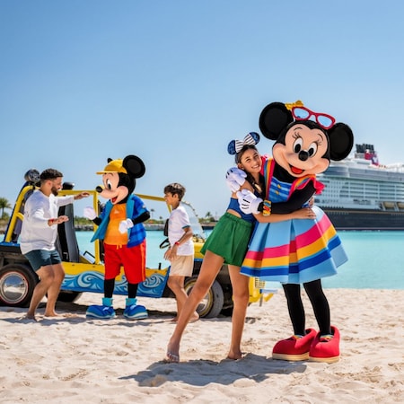 Mickey Mouse and Minnie Mouse greet a father and his teen son and daughter near a dune buggy on a beach