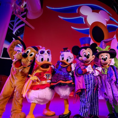 Mickey Mouse e seus amigos usando trajes de Halloween em frente à chaminé de um navio de cruzeiro da Disney