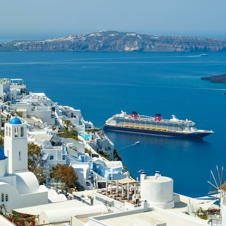 A Disney cruise ship entering the harbor of a Greek island