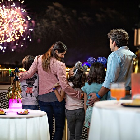 Un homme, une femme et leurs enfants regardent des feux d’artifice lors d’une farandole de desserts de feux d’artifice